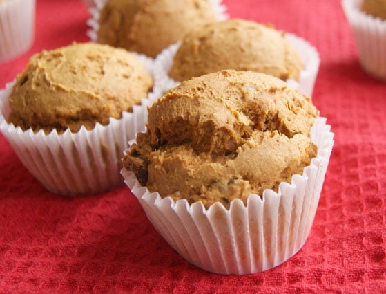 Pumpkin muffins in white wrappers on a red cloth