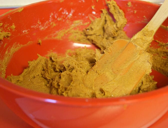 pumpkin batter in a red bowl with spatula