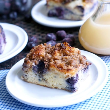 Square of french toast casserole on blue plate on blue checked napkin