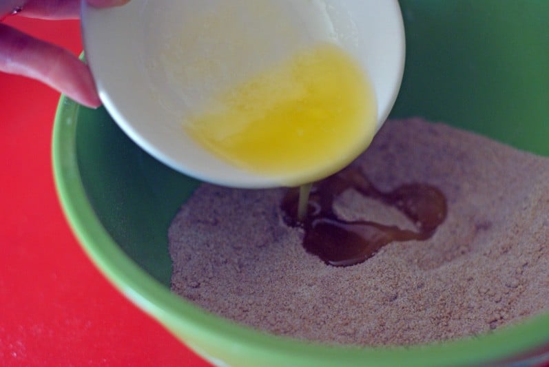 pouring butter into sugar and cinnamon