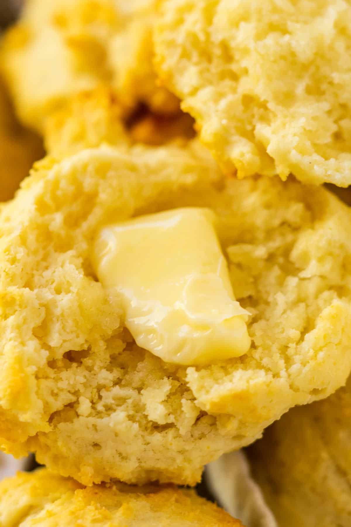 A split biscuit with a pat of butter on it