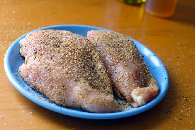 2 seasoned chicken breasts on a blue plate