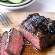 grilled steak sliced on a wooden cutting board