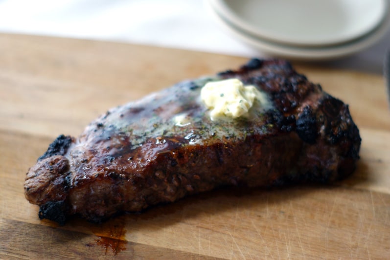 seasoned butter melting on a grilled steak