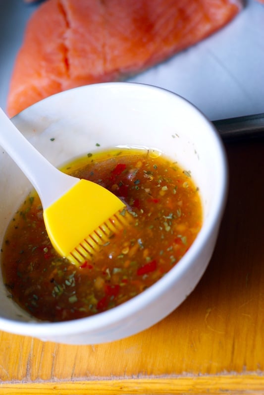 chili sauce and seasonings in a white bowl with yellow brush