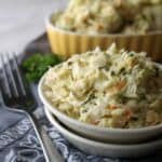 Cabbage coleslaw in white bowl on grey napkin and fork