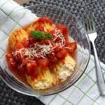 cheese manicotti in a glass dish on a green and white towel