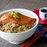 Asian pear fried rice topped with salmon in a white bowl
