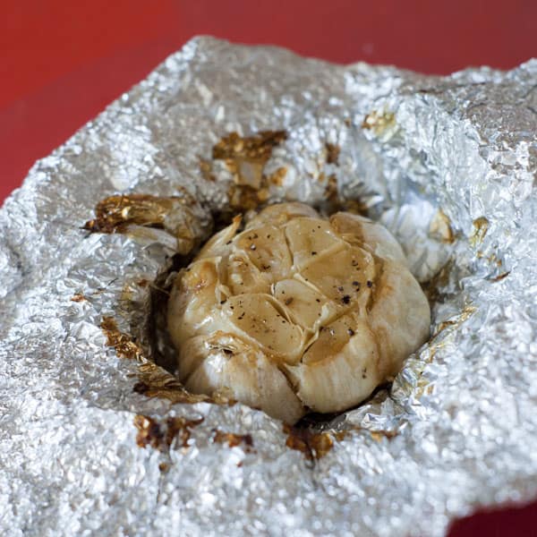 Finished Roasted Garlic in aluminum foil with olive oil, salt, and pepper