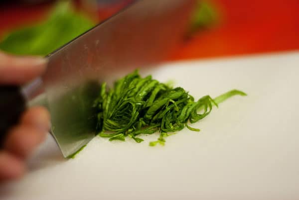 chopped basil leaves on a cutting board