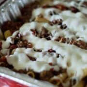 bechamel sauce drizzled over pasta al forno in foil pans