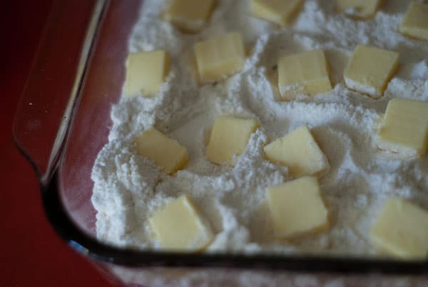cubed butter on top of the cake mix in a baking dish