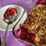 Cherry dump cake in a glass baking dish on a pink napkin