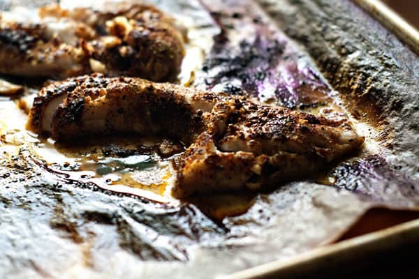 baked white fish on a baking sheet