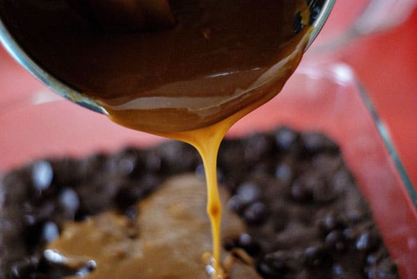 Caramel Sauce being poured over brownies from cake mix devil's food