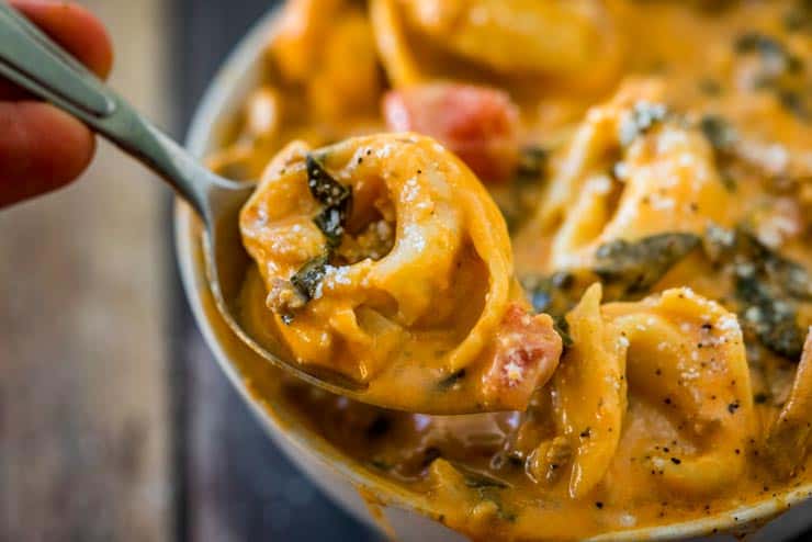 Spoon with a creamy tortellini on it