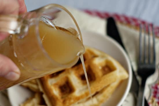Buttermilk syrup being poured on top of waffles