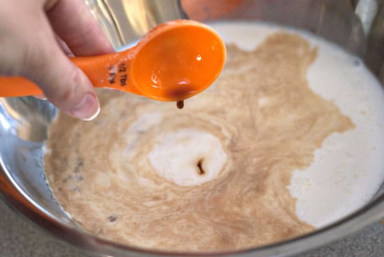 Eggs, half and half, cinnamon and vanilla with sugar and salt in a silver mixing bowl.