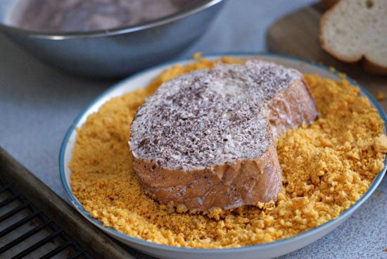 Dipping bread into a bowl of crushed cap'n crunch cereal.