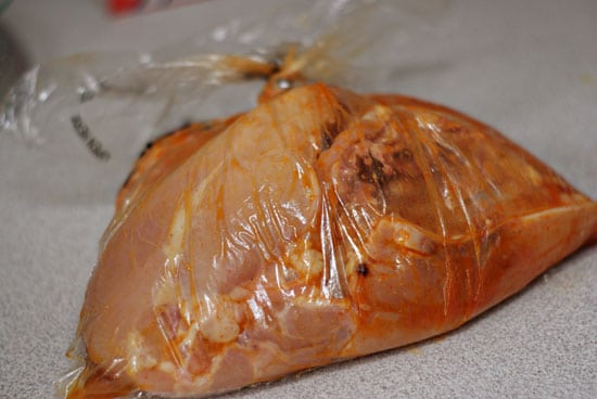 Raw chicken marinating in a bag