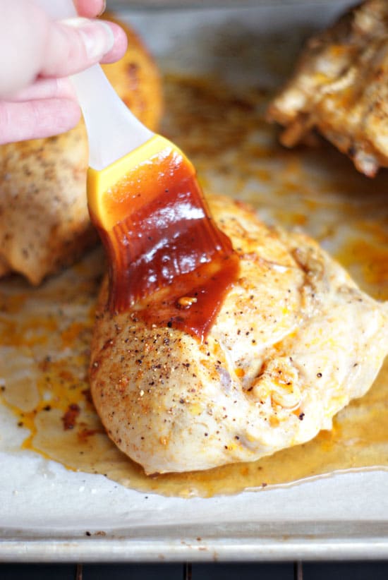 Brushing bbq sauce on a baked chicken breast