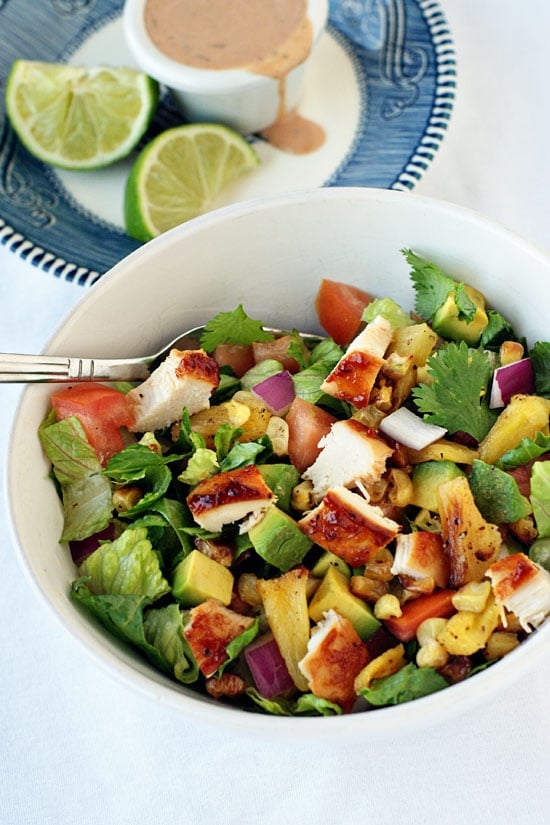 BBQ Chicken Chopped Salad with cilantro, corn and tomatoes in a large white bowl.