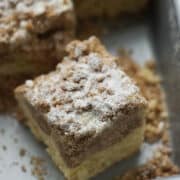 Slice of delicious crumb cake in a cake pan.