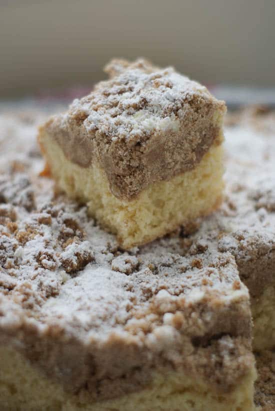 Slice of homemade German Crumb Cake on top of the rest of the cake.