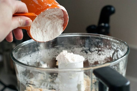 Pouring flour into a food processor.