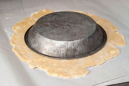 Silver pie pan on top of simple pie crust dough.