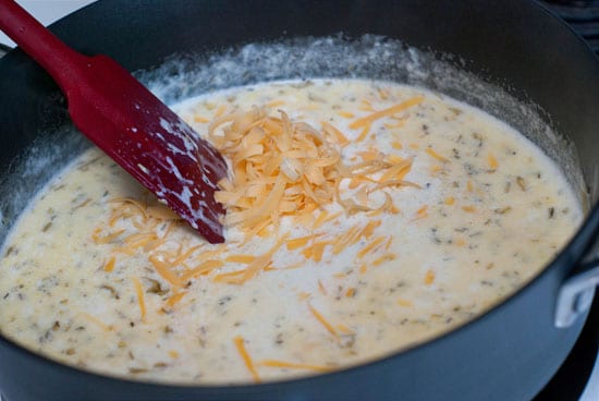 Mixing simple Potato Gratin ingredients in a large black skillet.