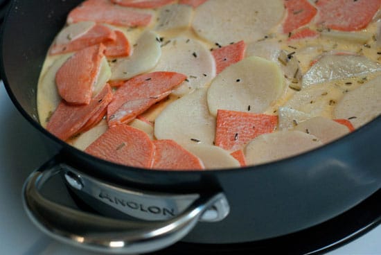 Cooking Sweet Potato Gratin recipe in a large black skillet.