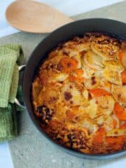 Easy Sweet Potato Gratin recipe in a large black skillet next to a wooden spoon.