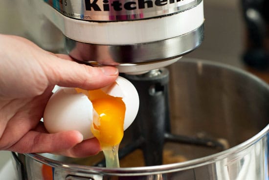 Cracking eggs into an electric mixer.