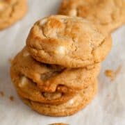 Stacked easy white chocolate chip macadamia nut cookies on parchment paper.