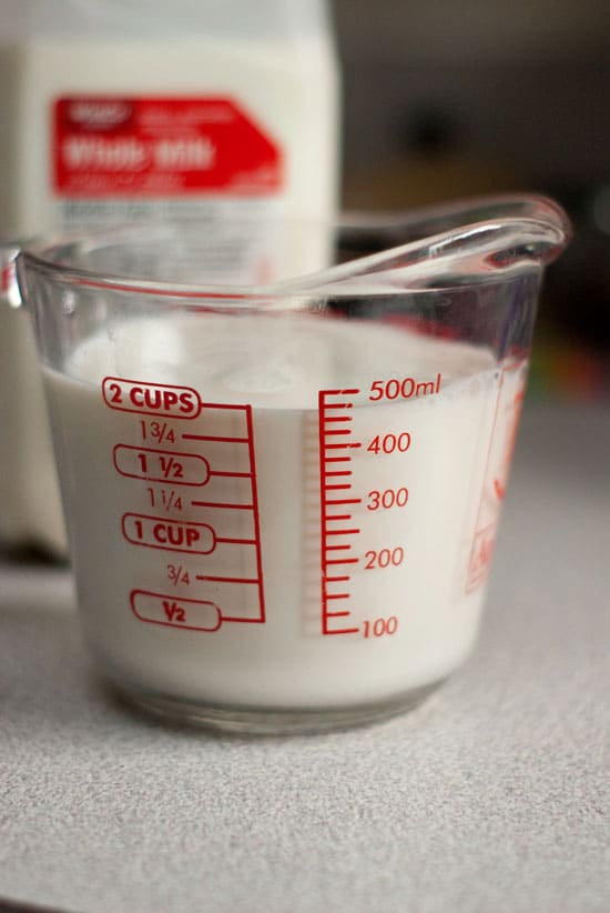 Two cups of Whole milk in a glass measuring cup.