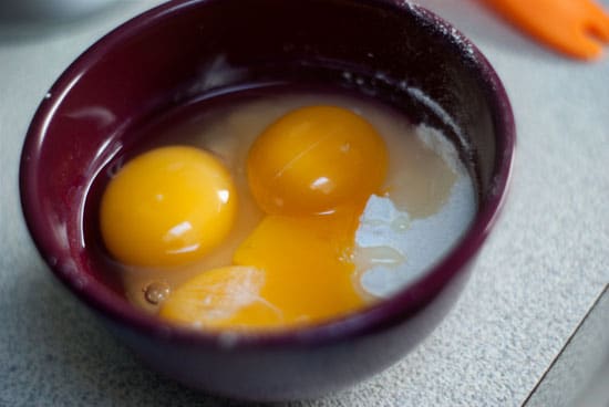 Eggs and cornstarch in a small red bowl.