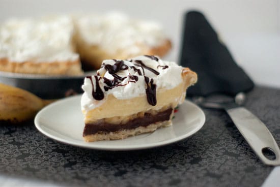 Homemade Banana Cream Pie in a small white plate on a table.