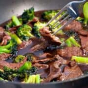 Easy beef and Broccoli Stir Fry in a large skillet with a silver fork.