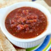 Fast Salsa recipe in a small white bowl surrounded by mexican tortilla chips.