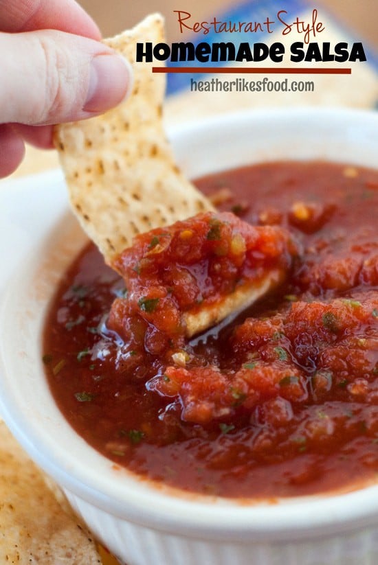 Scooping easy Restaurant Style Salsa out of a small white bowl with a tortilla chip.