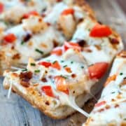 Simple Garlic Bread Pizza with mozzarella and tomatoes on a wooden board.
