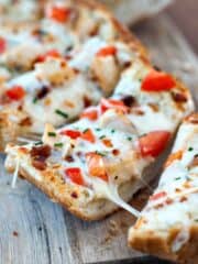 Simple Garlic Bread Pizza with mozzarella and tomatoes on a wooden board.