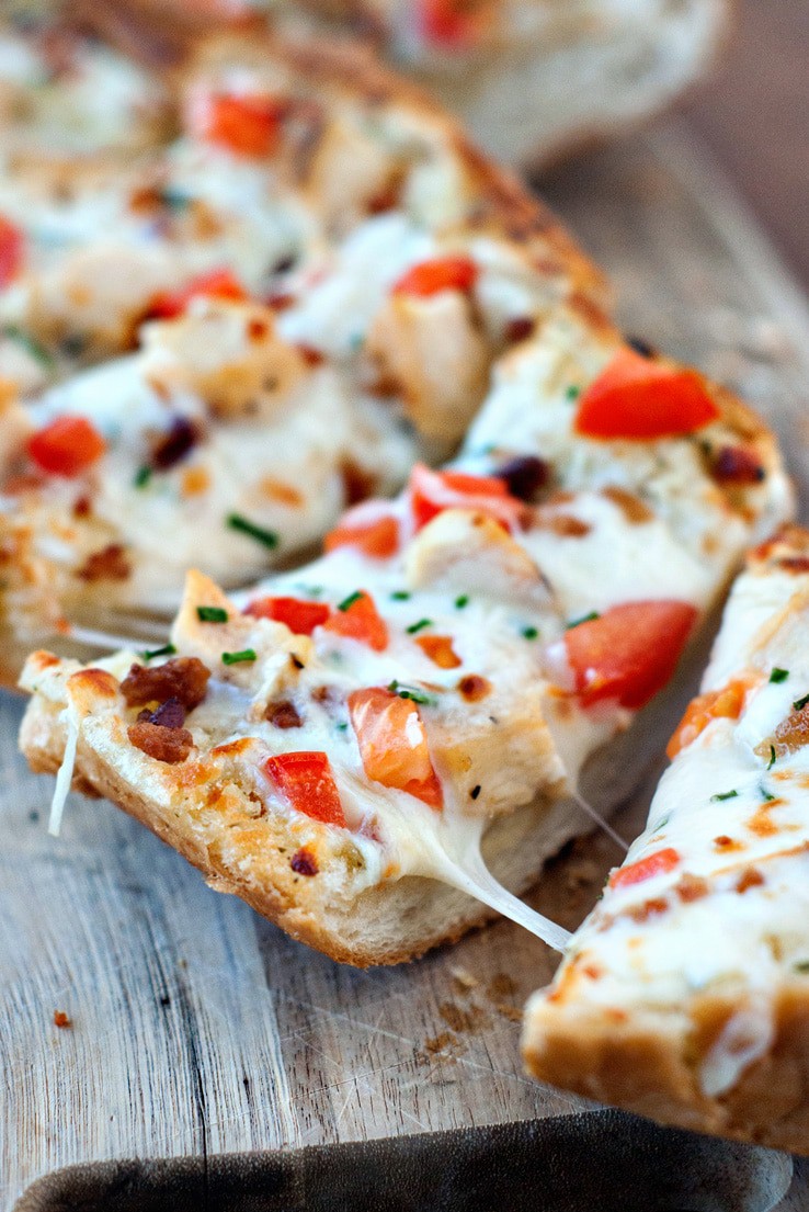 Splitting Chicken and Bacon Garlic Bread Pizza on a wooden board.