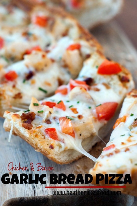 Easy Chicken and Bacon Garlic Bread Pizza being split apart on a wooden board.