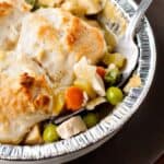 Biscuit Topped Chicken Pot Pie with gravy in a pie tin with a silver fork.