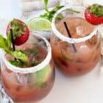 Two easy Strawberry Mojito Mocktails with mint, strawberries and sliced limes.