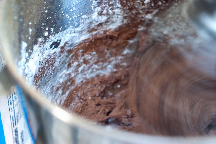 Mixing Chocolate Frosting in a mixing bowl with an electric mixer.