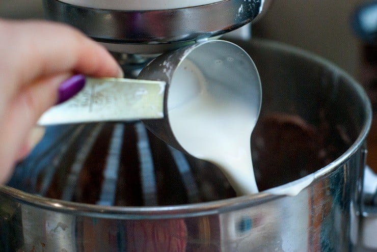 Pouring Heavy Cream and Vanilla Extract into an electric mixer.