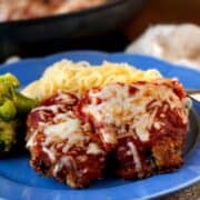 Beef Parmesan recipe in a blue plate with spaghetti noodles and broccoli.